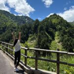 山で伸びをして深呼吸している画像