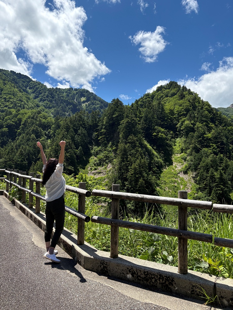 山で伸びをして深呼吸している画像